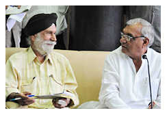 मुख्यमंत्री हुड्डा के बिलकुल बगल में बैठकर उन्हें समझाते पत्रकार एसएन परवाना