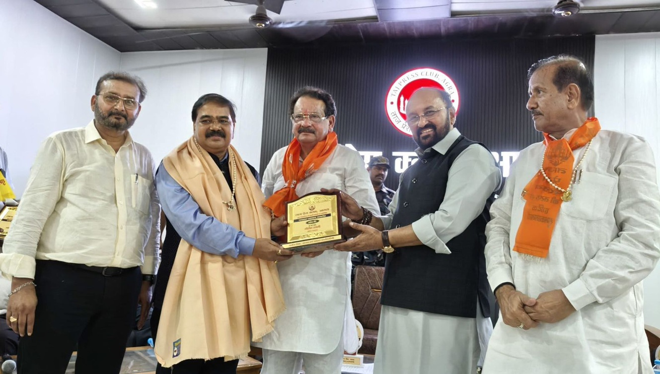 Group of men at an award ceremony exchanging a plaque on stage.