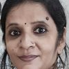 Close-up portrait of a South Asian woman with a bindi, nose ring, and earrings, looking at the camera.