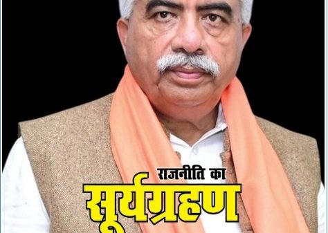 Hindi newspaper front page featuring a man in a beige vest and orange scarf, with a bold yellow headline 'राजनीति का सूर्य ग्रहण'.