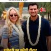 Two smiling young adults wearing flower garlands pose together outdoors, with a Hindi news headline overlaid at the bottom.