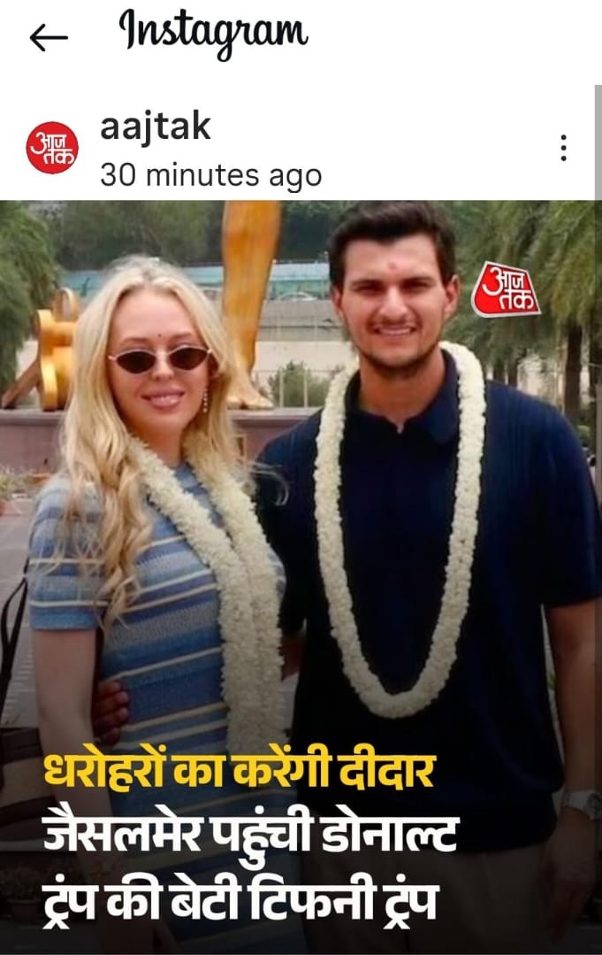 Two smiling young adults wearing flower garlands pose together outdoors, with a Hindi news headline overlaid at the bottom.