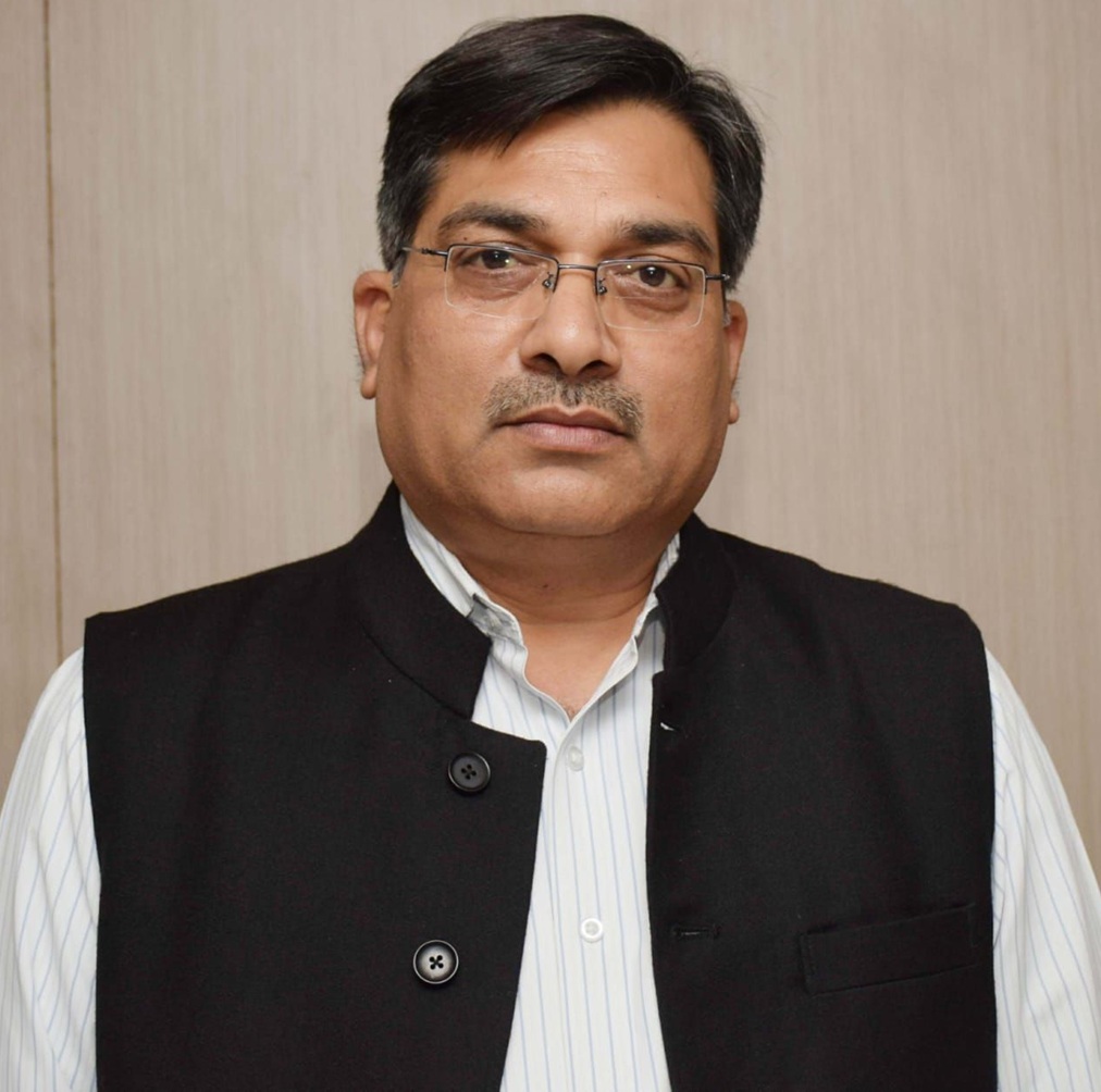 Portrait of a middle-aged man with short black hair and glasses, wearing a white striped shirt and a black waistcoat, looking at the camera.