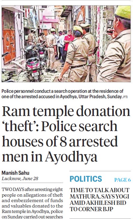 Police officers conduct a search operation in a narrow street, with bystanders and parked motorcycles nearby.
