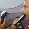 Man with his mouth open as a tester places a handheld device near his lips, with another device in the tester's other hand.