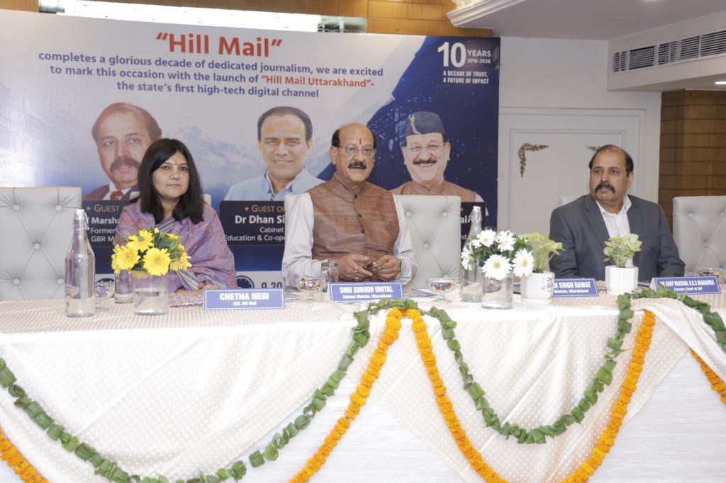 ccb6f33f-ab0e-4467-8dd1-26d339118293 | No. 1 Indian Media News Portal Panelists seated at a conference table during a Hill Mail launch event, with garlands, nameplates, and a banner in the background.