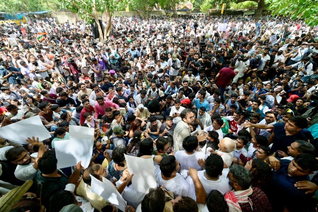 cjp_jm | No. 1 Indian Media News Portal Large crowd of protesters packed together outdoors, many holding up white placards amid green trees in the background.