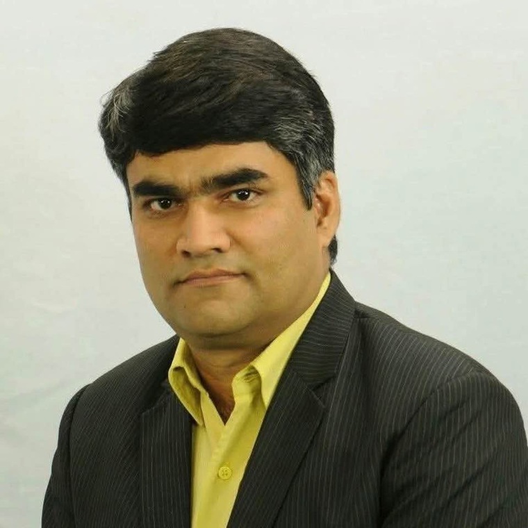 girijesh mishra | No. 1 Indian Media News Portal Portrait of a man in a dark pinstripe suit and yellow shirt, looking at the camera.