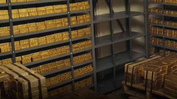 Vault full of gold bars on metal shelves, with a Hindi news headline asking if the government sold gold and RBI clarification in the frame.