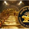 Gold bars stacked in a vault with the Reserve Bank of India emblem in the foreground