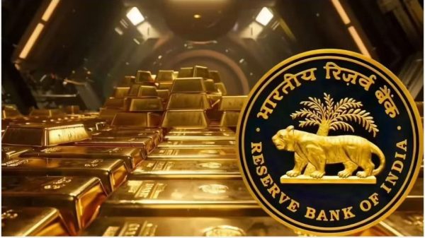 Gold bars stacked in a vault with the Reserve Bank of India emblem in the foreground