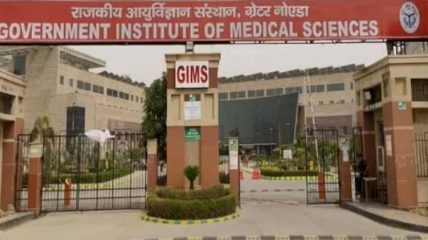 Entrance gate of Government Institute of Medical Sciences (GIMS) with a large red sign overhead and gated campus.
