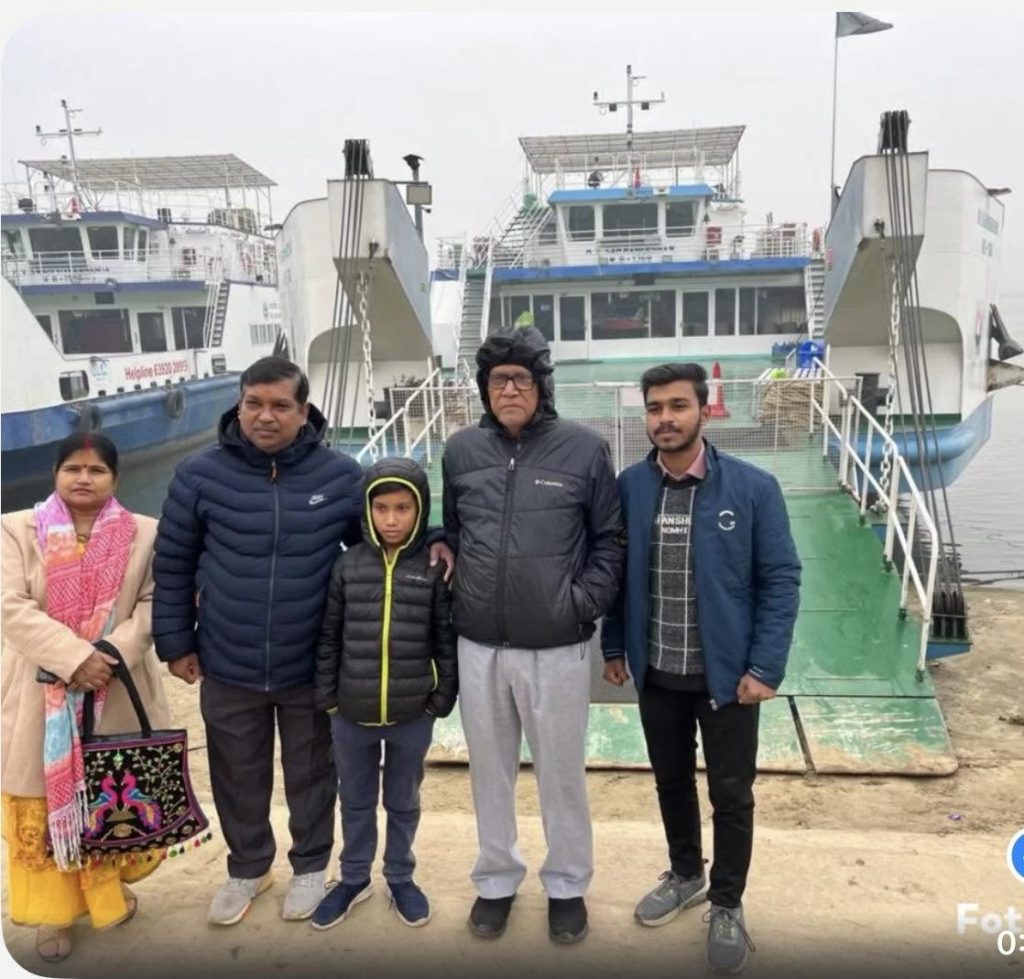 Screenshot | No. 1 Indian Media News Portal Family of five wearing jackets stands on a dock with ferries in the background at a harbor.