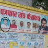 Political campaign banner on a yellow wall showing several candidate photos; circled man in a light blue shirt; Hindi text above.