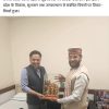 कार्यालय में दो पुरुष एक ट्रॉफी-डिब्बे के साथ एक-दूसरे को सम्मान दे रहे हैं