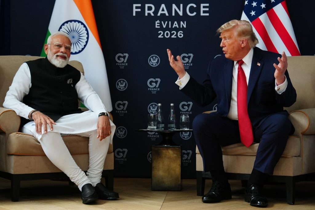 Two world leaders sit in armchairs on a stage with flags behind them, appears to be a formal discussion at an international summit.