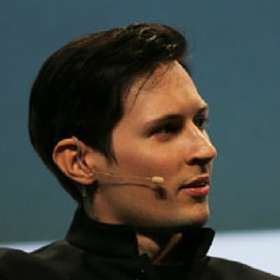 Side profile of a man with a headset microphone speaking at an event.
