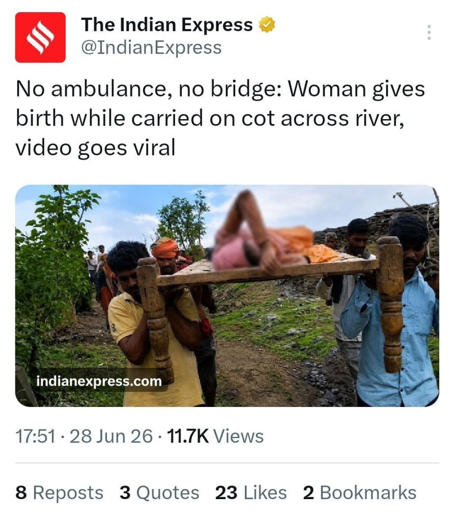 People carry a woman on a wooden cot along a rural path, likely en route to medical help.
