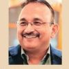 Portrait of Pratap Somvanshi, smiling man with glasses, with a beige background and the caption 'Pratap Somvanshi' beneath.
