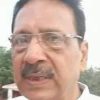 Close-up portrait of a middle-aged man with glasses and a mustache outdoors