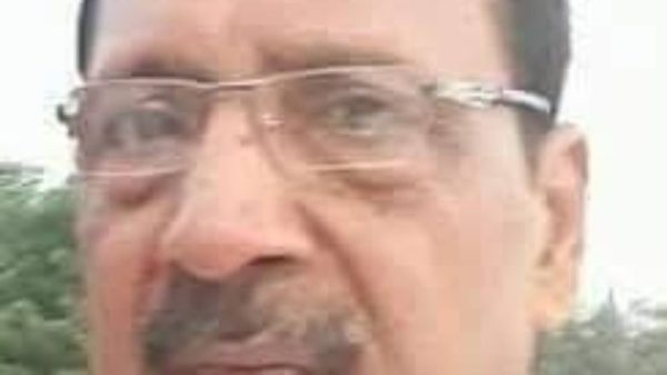 Close-up portrait of a middle-aged man with glasses and a mustache outdoors