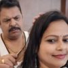 Man with a mustache behind a woman, grooming or combing her hair as she smiles softly.