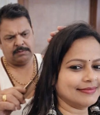 Man with a mustache behind a woman, grooming or combing her hair as she smiles softly.