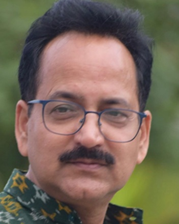 Jaiprakash_pandey | No. 1 Indian Media News Portal Head-and-shoulders portrait of a man with black hair, mustache, glasses, wearing a camouflage shirt, outdoors with greenery in the background.