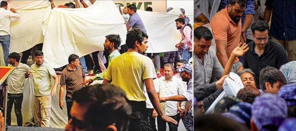 Crowd of people around a large white banner being unfurled or held up at a busy outdoor event.