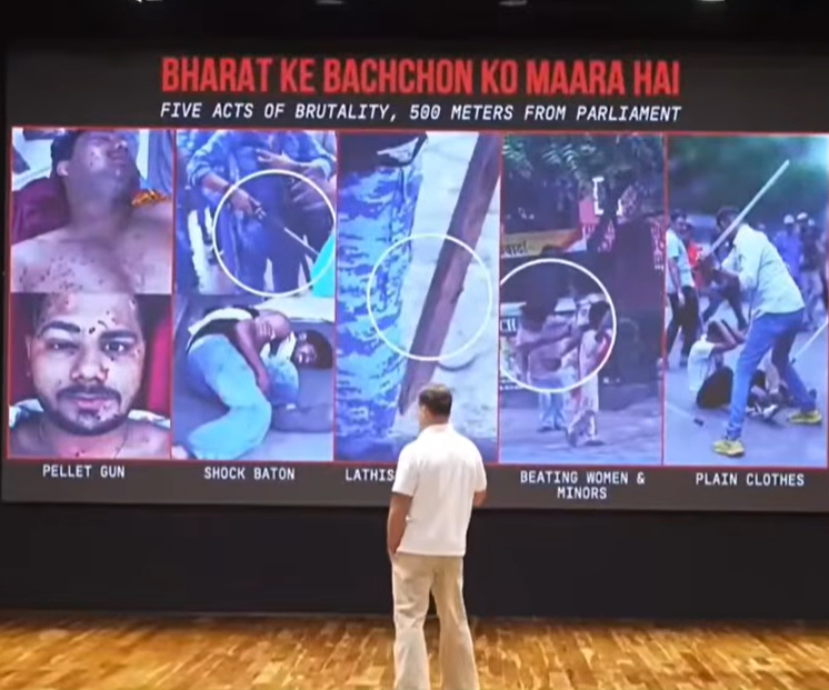 Man facing a large screen infographic titled 'Bharat ke Bachchon ko Maara Hai' showing five acts of brutality: pellet guns, shock batons, lathis, beating women and minors, and plain-clothes officers.