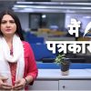 Female news presenter in pink with a white scarf stands in a newsroom; Hindi caption मैं पत्रकार हूँ on screen.