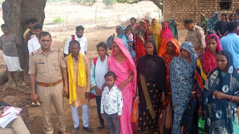 chandauli_1 | No. 1 Indian Media News Portal Group of villagers and a uniformed officer standing outdoors under a tree in a rural area, with people in colorful traditional clothing.