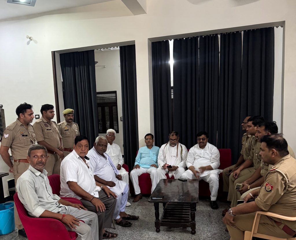 ed9735f4-52c1-4186-b120-f0fd70c87180 | No. 1 Indian Media News Portal Group of men in khaki uniforms and white clothes seated around a table in a meeting room with dark curtains in the background.