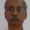 Portrait of a middle-aged man with gray hair and a mustache, wearing glasses and a white shirt, facing the camera.