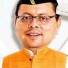 Portrait of a man wearing glasses, an orange kurta, and a black cap, smiling at the camera.