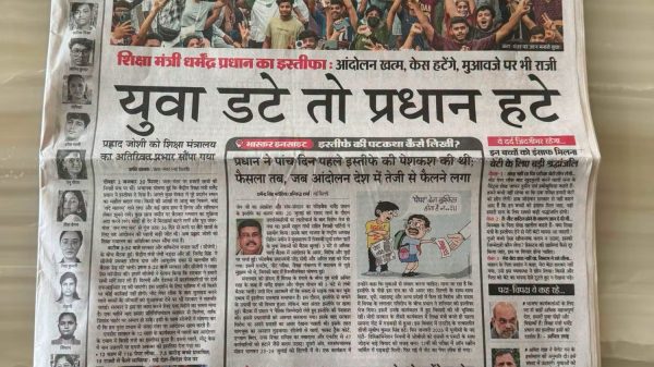 Front page of a Hindi newspaper showing a large crowd rally image with bold headlines above and below the photo.