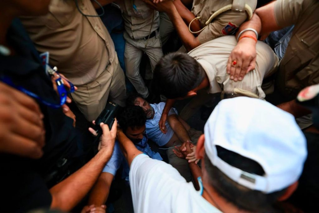 img_9872 | No. 1 Indian Media News Portal Crowd of uniformed responders surround a man seated on the ground, reaching in to assist.