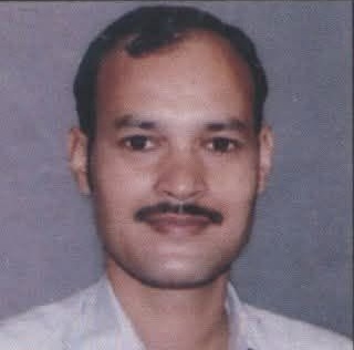 khushal | No. 1 Indian Media News Portal Portrait of a man with a mustache and short hair against a gray background.