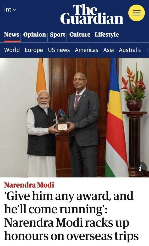 modi_guardian | No. 1 Indian Media News Portal Two men in formal attire exchange a glass award in a ceremonial setting, with national flags in the background.