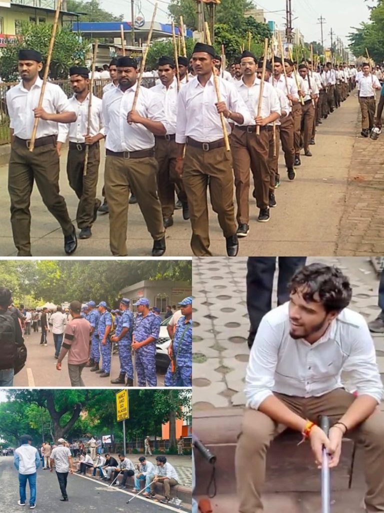 msf_1 | No. 1 Indian Media News Portal Group of men in white shirts and brown pants marching in formation holding long wooden staffs, on a street parade.