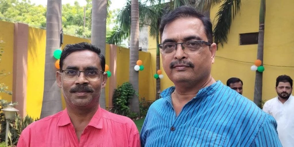 neeraj_vivek | No. 1 Indian Media News Portal Two men with glasses pose for a photo at an outdoor celebration with balloons and palm trees in the background.