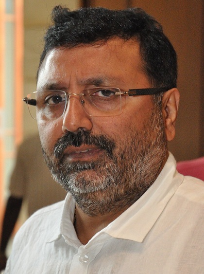 Close-up of a man with glasses and a graying beard looking at the camera.