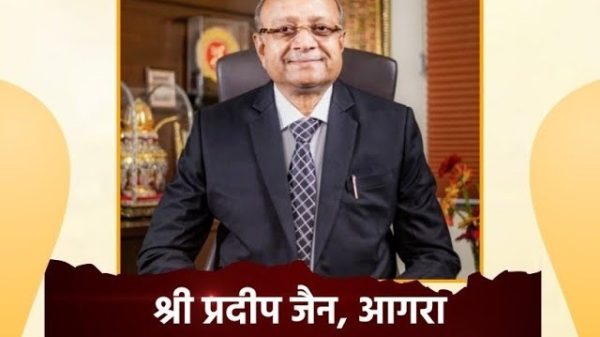 Portrait of a man in a dark suit and tie, seated in an office, identified as Chairman of PNC Infratech Limited (text on banner)