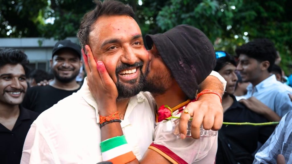 saurabh | No. 1 Indian Media News Portal Two men embrace and laugh at a celebration, with a cheering crowd in the background.