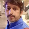 Portrait of a man with a blue kurta in an indoor lounge, looking at the camera.