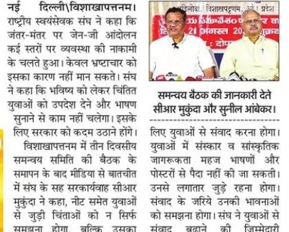 Hindi newspaper clipping about a Jantar-Mantar protest; two men speak at a press meet with a red banner in the background.