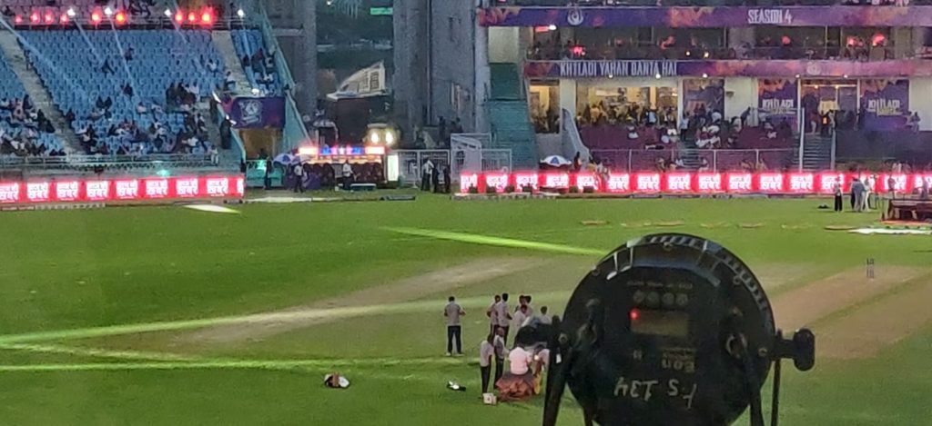 aaj ki khabar ekana | No. 1 Indian Media News Portal Cricket stadium with crowd in stands; on-field group near a large circular floodlight rig and a vehicle with flashing lights.
