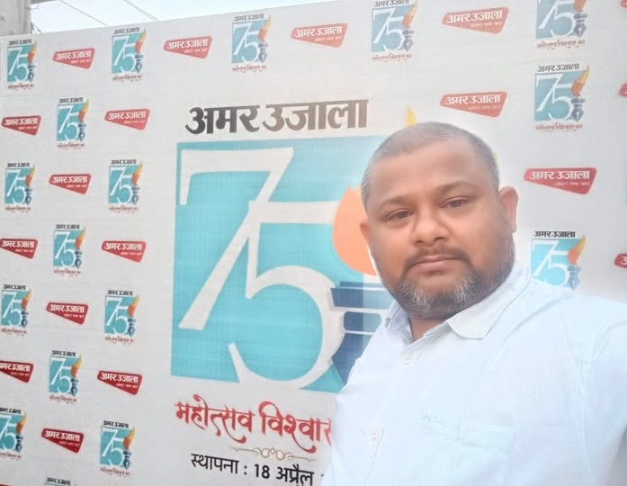 abhishek singh | No. 1 Indian Media News Portal Man in a light blue shirt taking a selfie in front of a backdrop with Amar Ujala 75th anniversary logos and text.