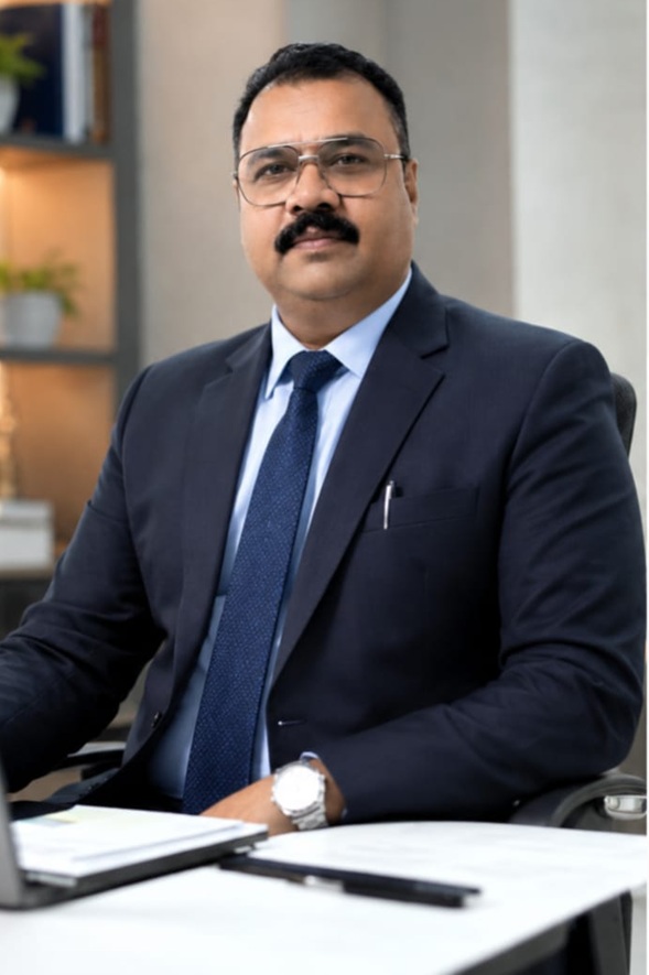 alok singh | No. 1 Indian Media News Portal Professional man in a dark suit and blue tie seated at an office desk
