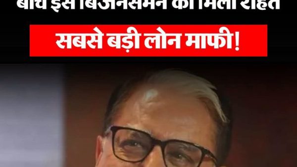 Hindi news thumbnail about a massive loan relief; red banner says 'सबसे बड़ी लोन माफी' with a smiling man wearing glasses in the foreground.
